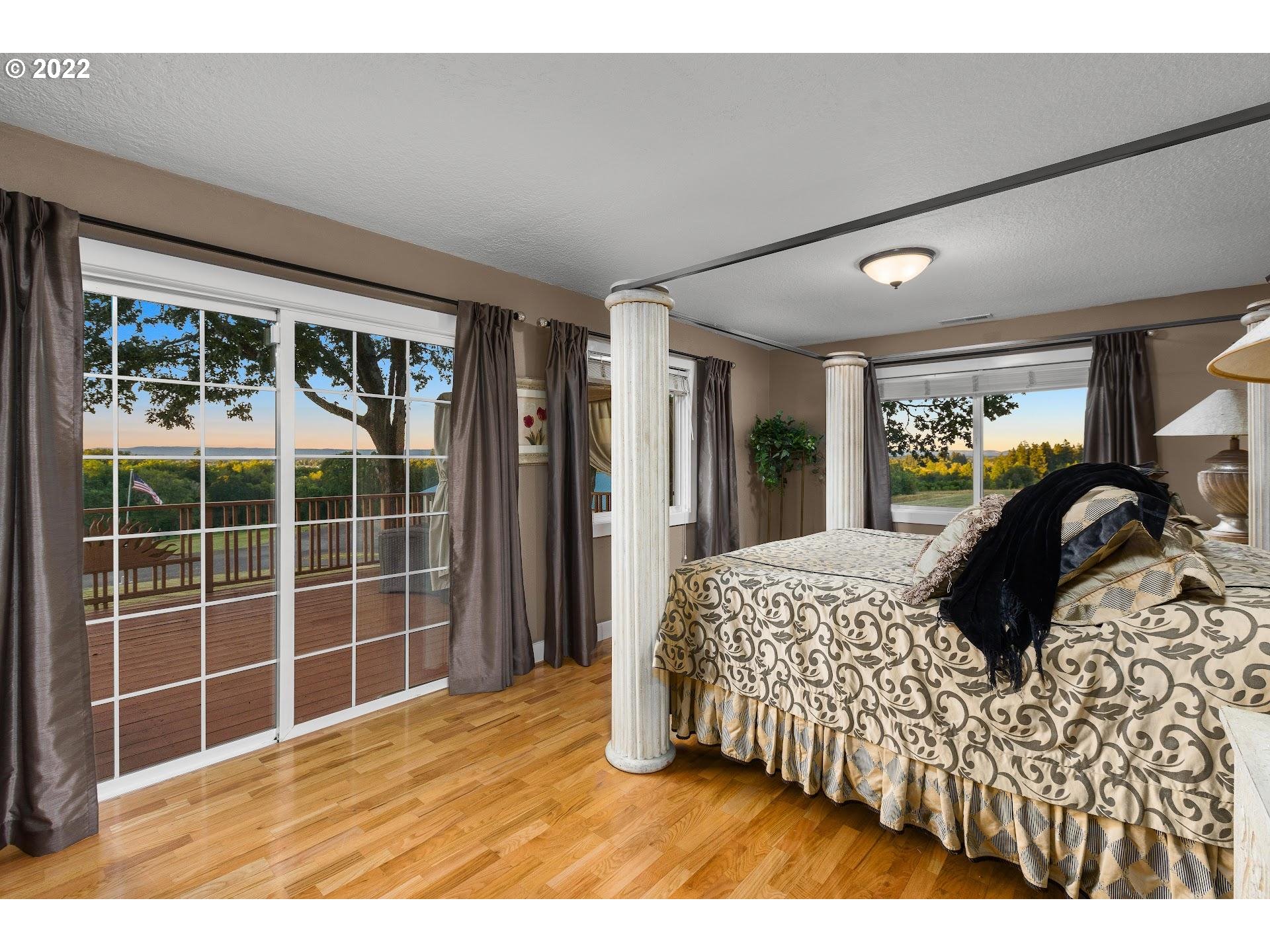 3995 Southwest Lafollett Road Cornelius, OR 97113 - Photo 10 of 32 a bedroom with a large bed and a large window
