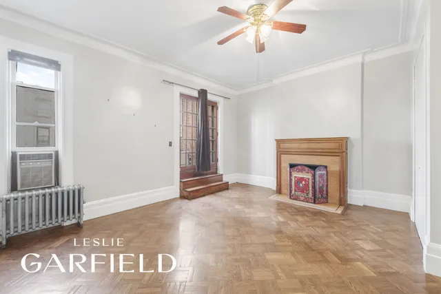 an empty room with windows and ceiling fan