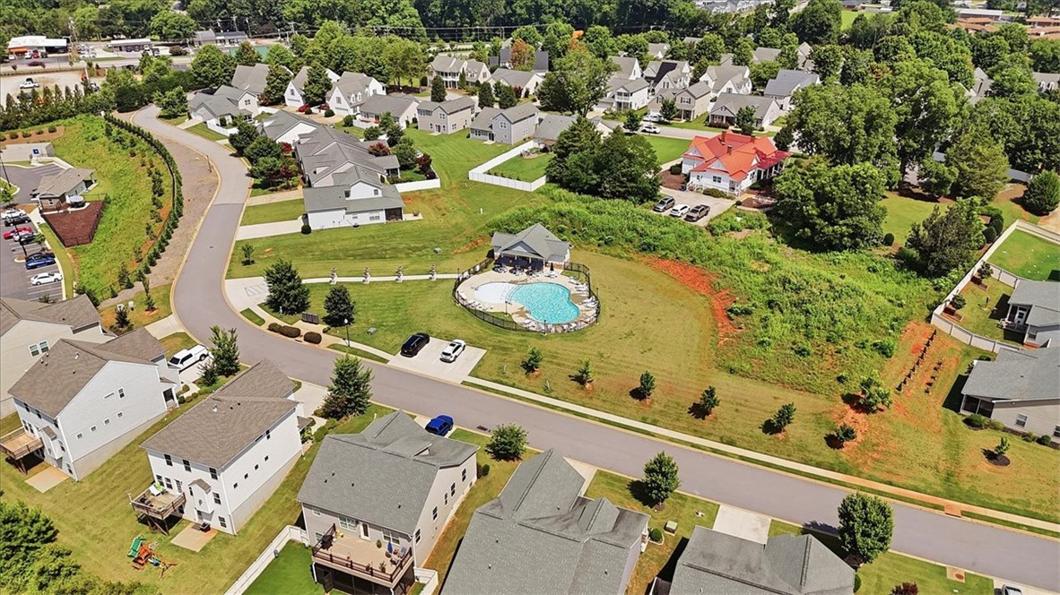208 Grassy Creek Way Pendleton, SC 29670 - Photo 39 of 43 An aerial perspective reveals a serene neighborhood setting with ample green spaces and a refreshing community pool.