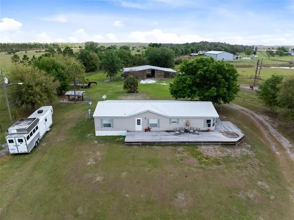 an aerial view of a house with pool large trees and outdoor seating