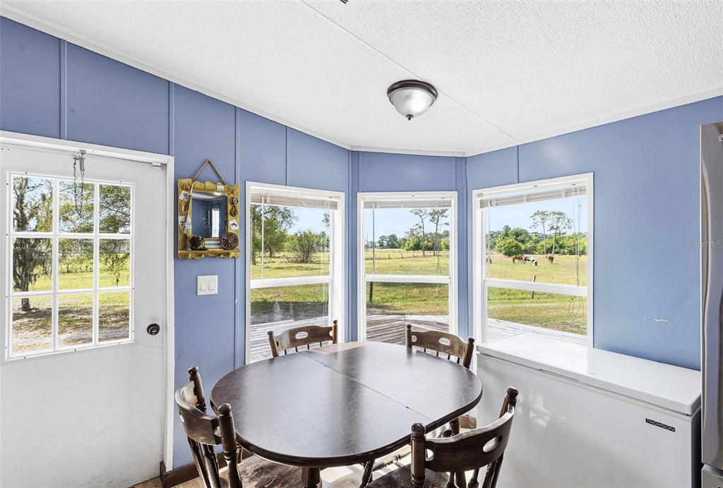3591 North Canoe Creek Road Kenansville, FL 34739 - Photo 12 of 42 a dining room with furniture window and wooden floor