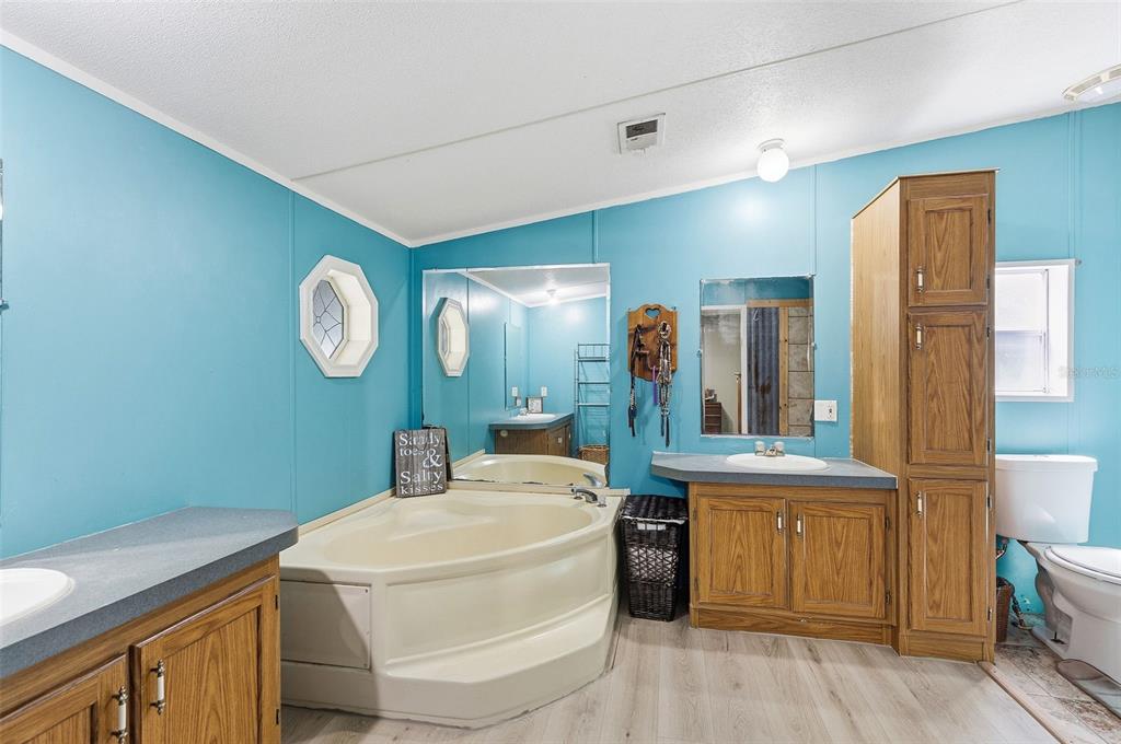 3591 North Canoe Creek Road Kenansville, FL 34739 - Photo 19 of 42 a room with cabinets a sink and a mirror