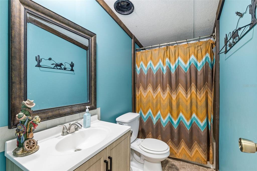 3591 North Canoe Creek Road Kenansville, FL 34739 - Photo 24 of 42 a bathroom with a sink mirror vanity and toilet