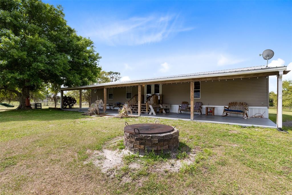 3591 North Canoe Creek Road Kenansville, FL 34739 - Photo 8 of 42 a view of a backyard with table and chairs and potted plants