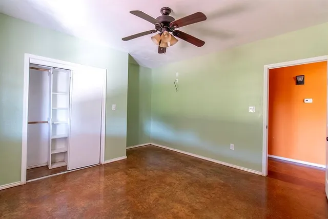 an empty room and closet area with fan