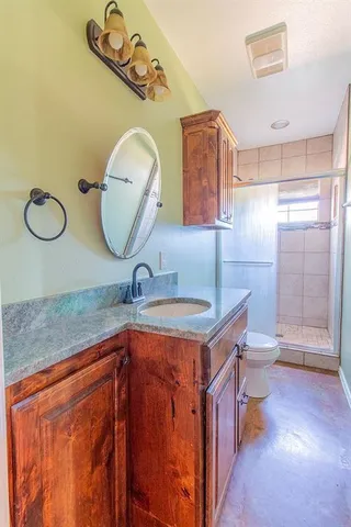 a bathroom with a toilet a sink and mirror