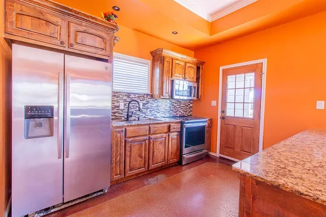 a kitchen with stainless steel appliances granite countertop a refrigerator and cabinets