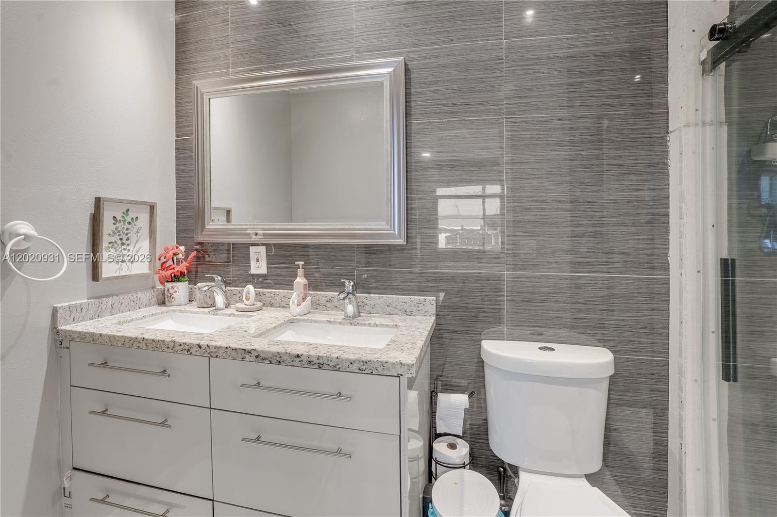1360 Northwest 77th Street Miami, FL 33147 - Photo 22 of 41 a bathroom with a toilet sink vanity and mirror