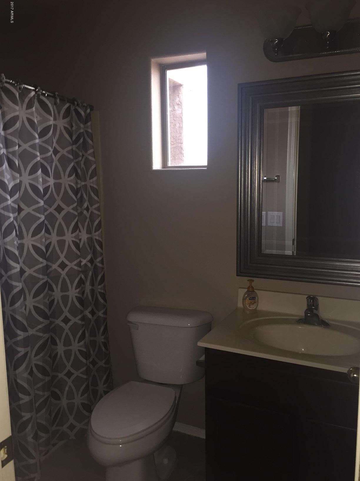 17544 West Hearn Road Surprise, AZ 85388 - Photo 11 of 17 a bathroom with a toilet a sink and a mirror