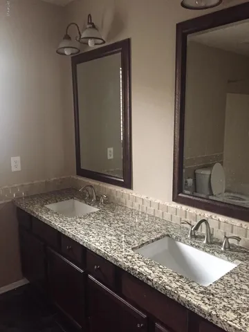 a bathroom with a granite countertop sink and a mirror