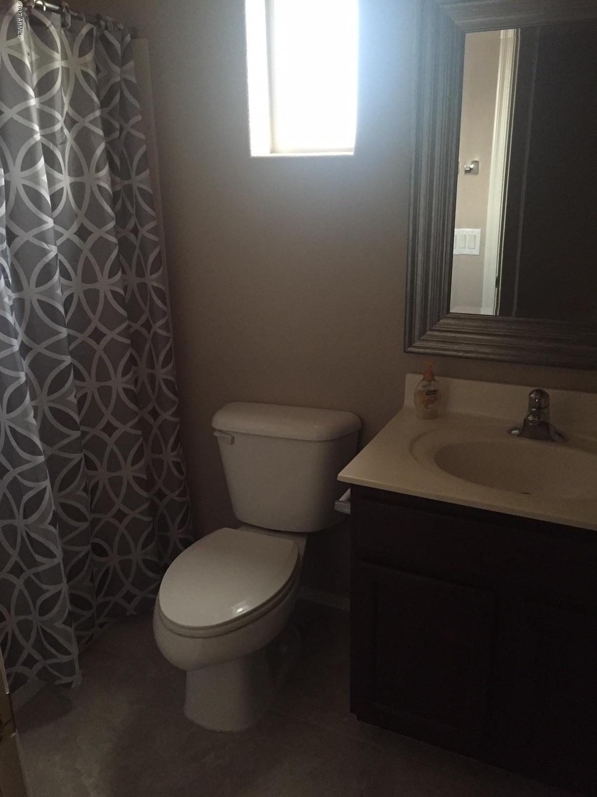 17544 West Hearn Road Surprise, AZ 85388 - Photo 14 of 17 a white toilet sitting next to a bathroom sink