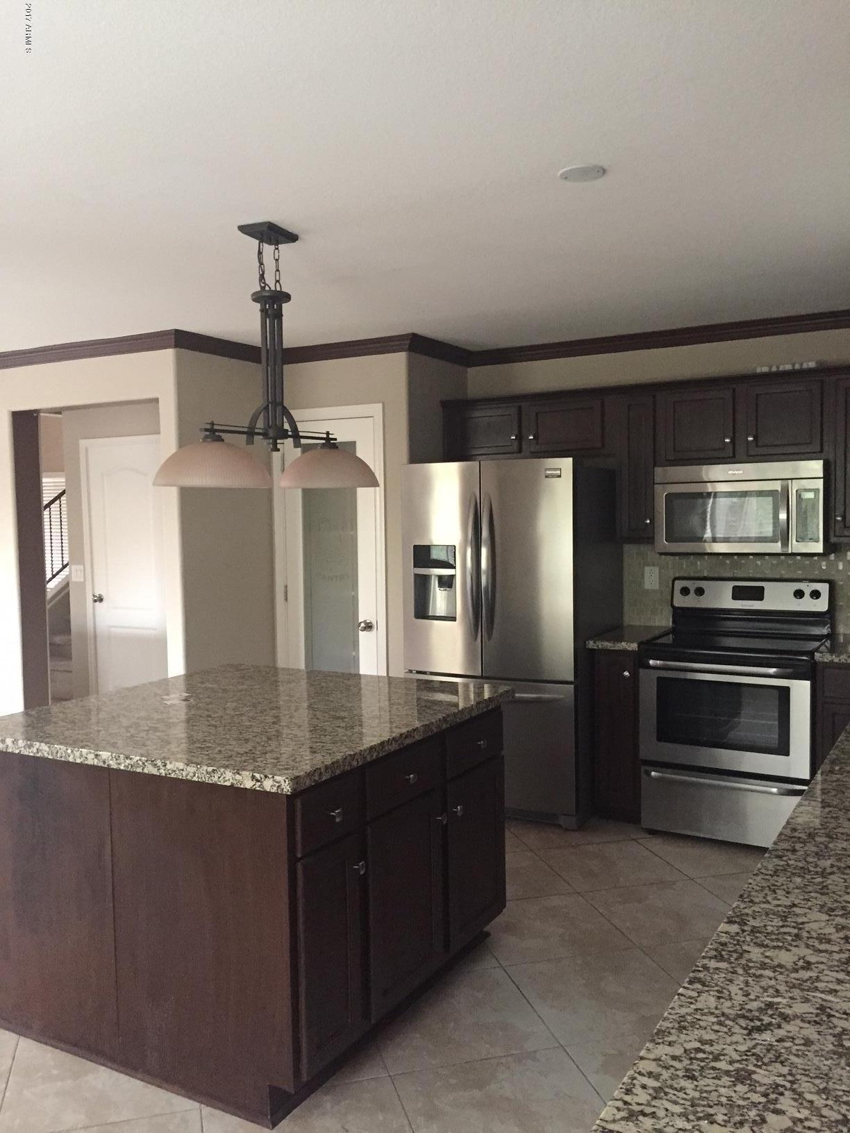 17544 West Hearn Road Surprise, AZ 85388 - Photo 4 of 17 a kitchen with stainless steel appliances granite countertop a sink and a refrigerator