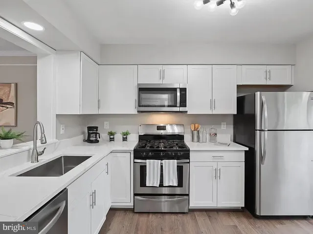 a kitchen with white cabinets and stainless steel appliances