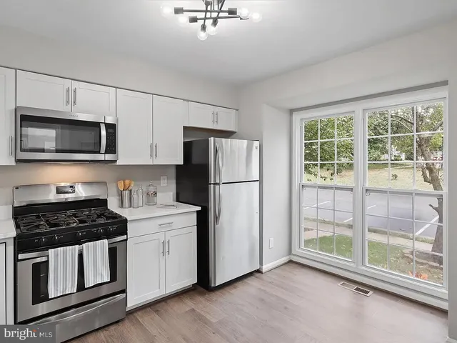 a kitchen with stainless steel appliances granite countertop a refrigerator a stove a sink and a microwave