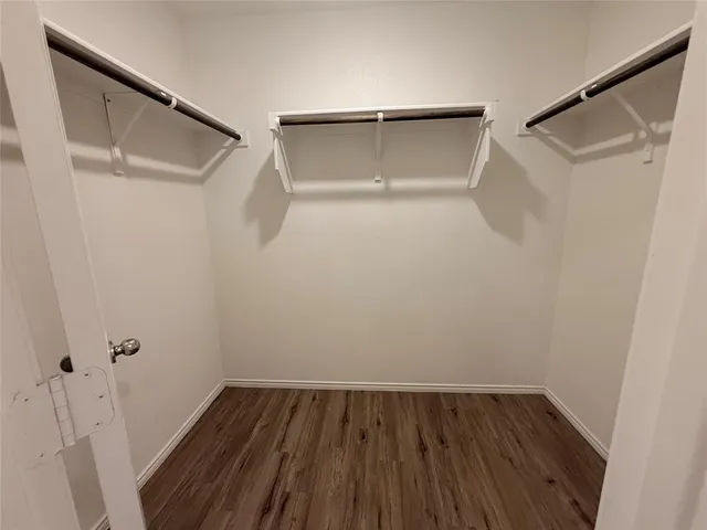 a view of walk in closet with wooden floor