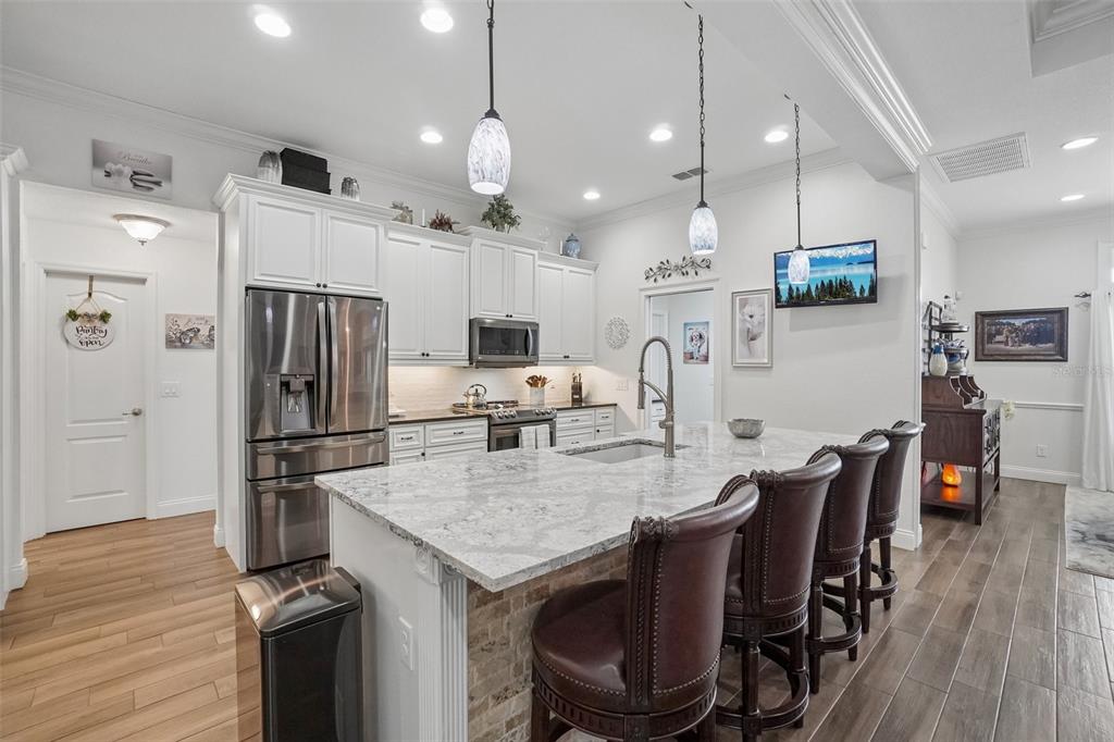 3934 Connersville Road Bartow, FL 33830 - Photo 21 of 81 a kitchen with kitchen island a refrigerator a stove a dining table and chairs with wooden floor