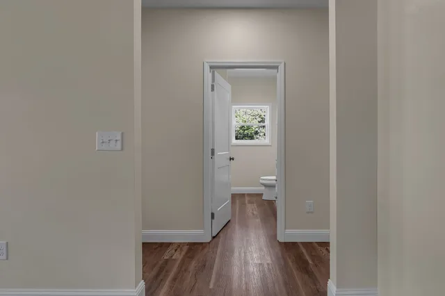a view of room with wooden floor and a toilet