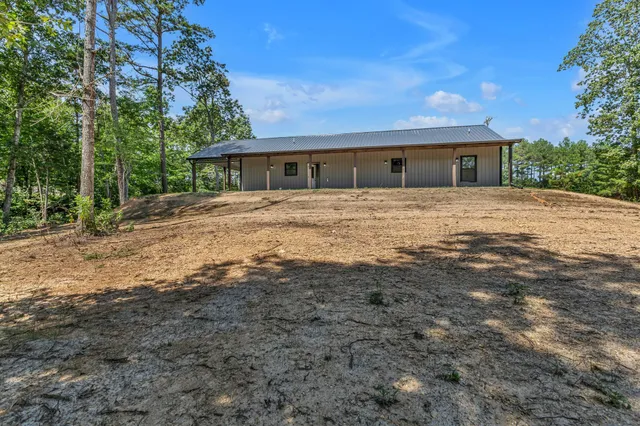 a front view of a house with a yard and trees