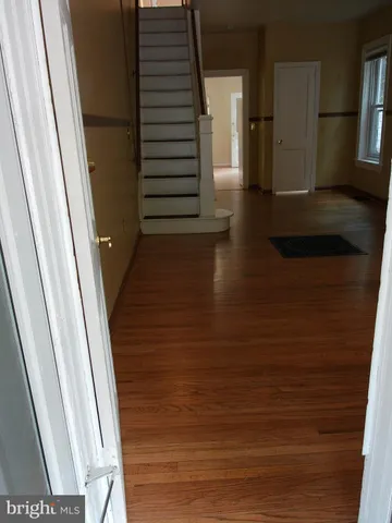 an empty room with wooden floor and a window