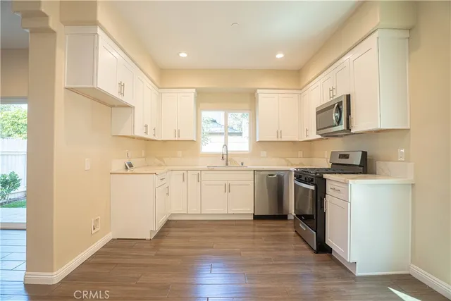a kitchen with granite countertop white cabinets and white appliances