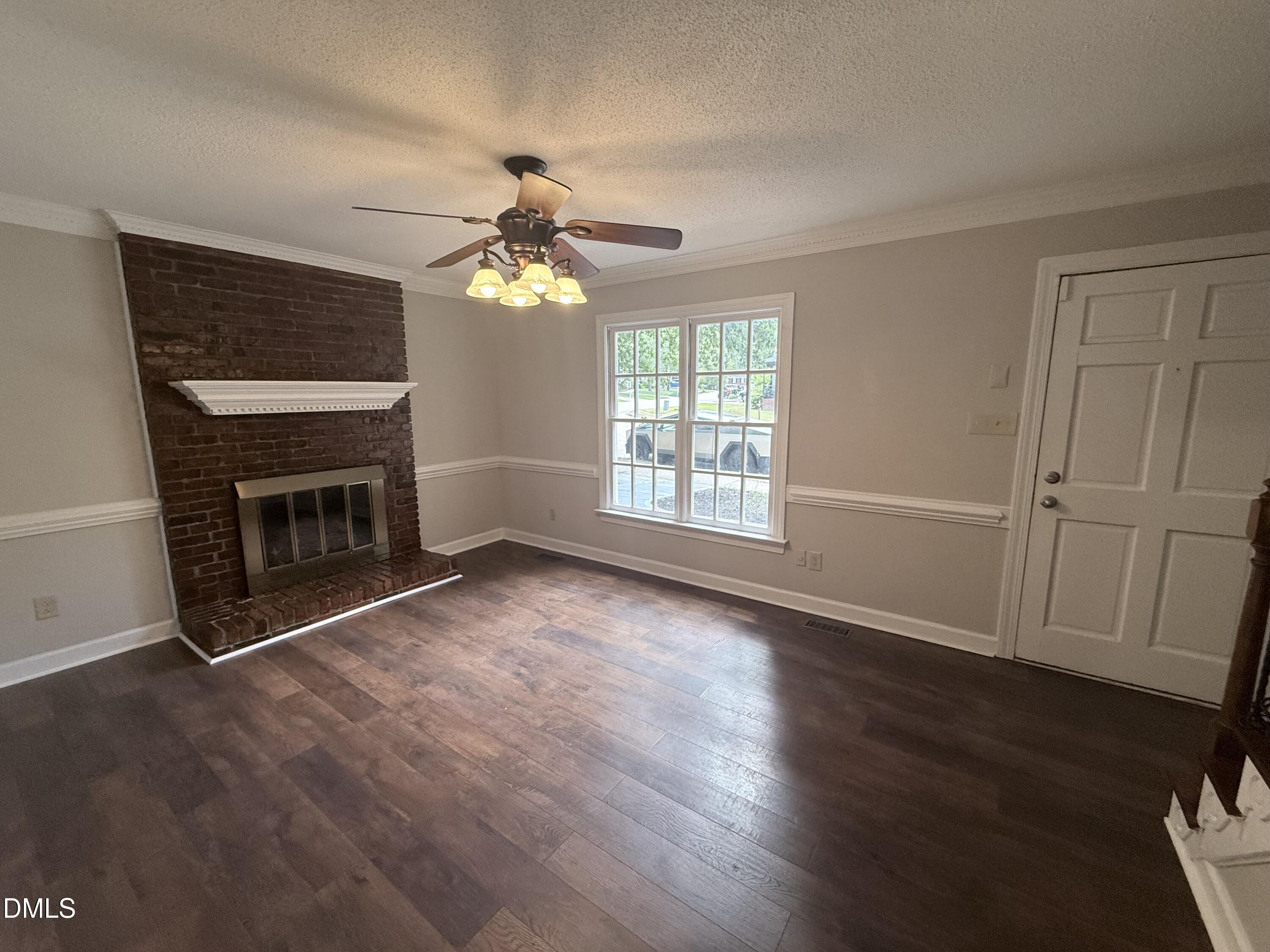 2900 Broadlands Drive Raleigh, NC 27604 - Photo 42 of 60 an empty room with wooden floor fireplace and windows