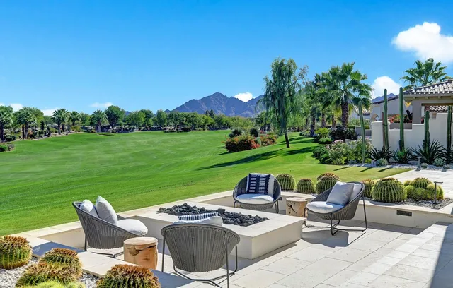 a view of a patio with couches chairs potted plants and a big yard