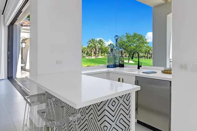 a kitchen with stainless steel appliances kitchen island a white table and chairs in it
