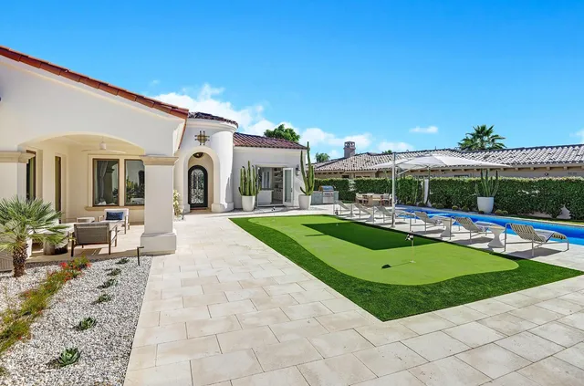a view of a house with swimming pool and a yard