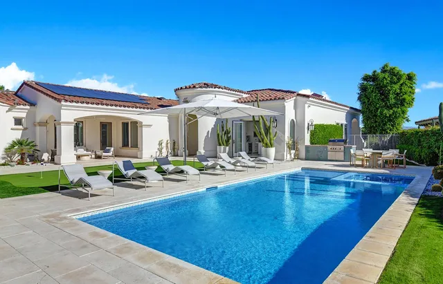 a view of a house with swimming pool and sitting area
