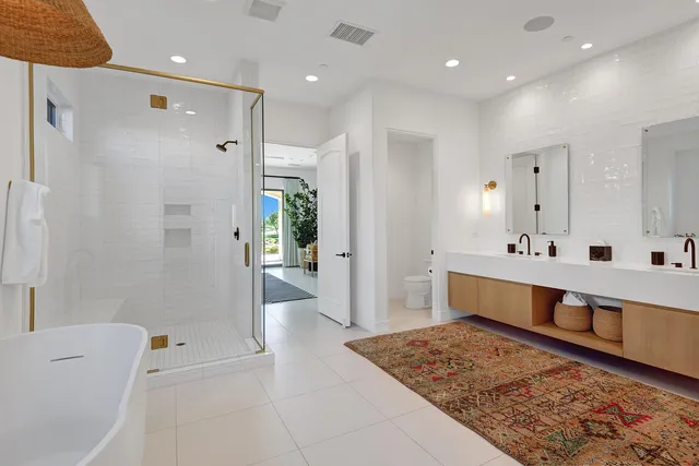 a bathroom with double vanity and a shower