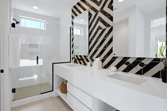 front view of a house with potted plants and palm trees