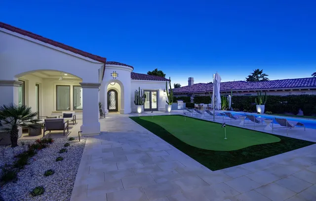 a view of a house with a yard porch and a table and chairs