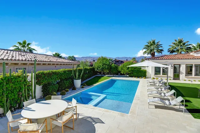 a view of a patio with table and chairs under an umbrella