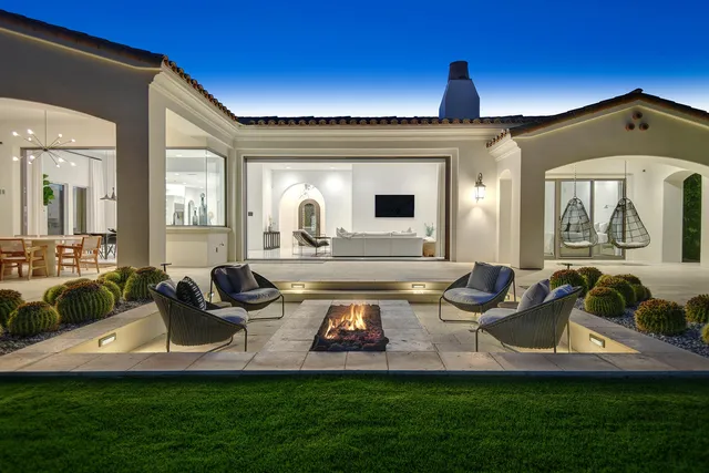 a front view of a house with swimming pool having outdoor seating