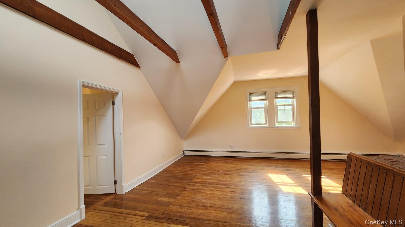 92 Roe Avenue, Unit 3 Highland Falls, NY 10928 - Photo 9 of 17 Spacious living room featuring exposed wood beams, sloped ceilings, wood-finish flooring, plenty of windows for ample light
