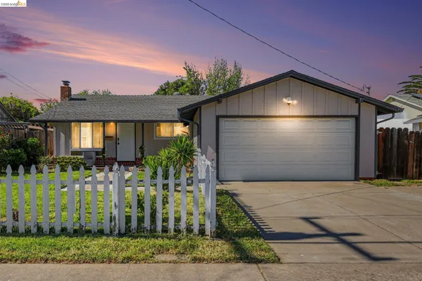 a front view of a house with a yard and potted plants