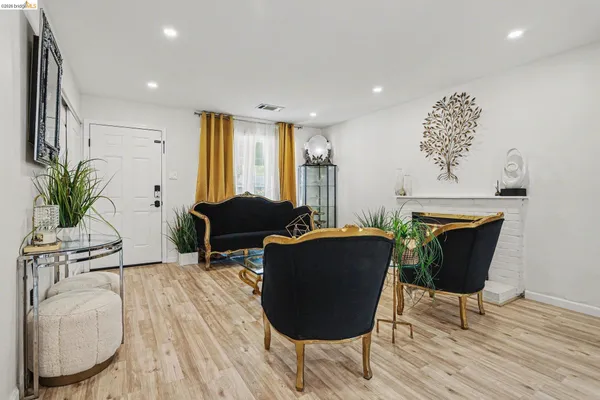 a living room with furniture a wooden floor and a chandelier