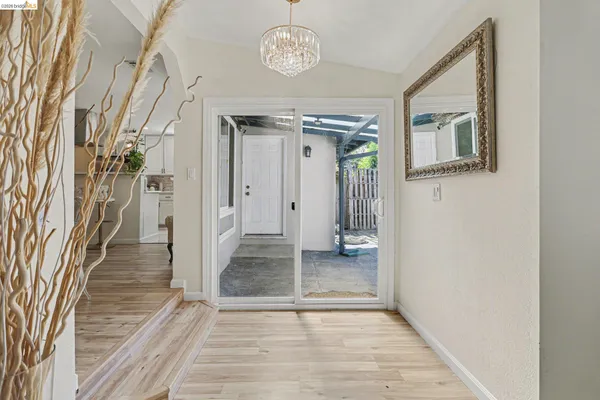 a view of a hallway with wooden floor and a living room