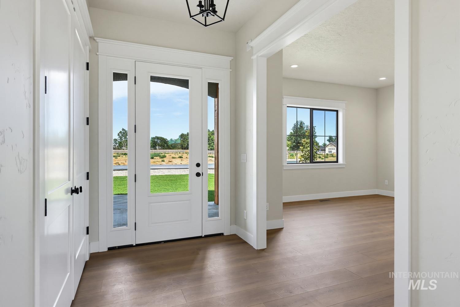 5054 Heritage Drive Marsing, ID 83639 - Photo 21 of 38 Foyer featuring a white entry door with side lites, wood-finish flooring, and a black geometric light fixture