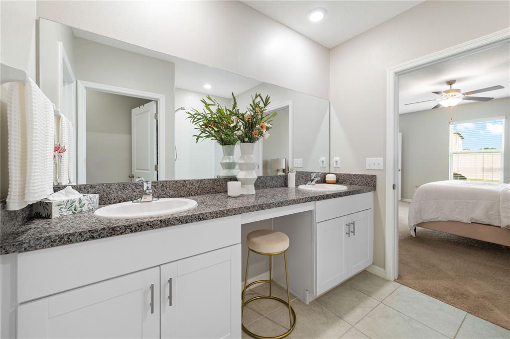 9448 Lemon Drop Loop Ruskin, FL 33573 - Photo 13 of 28 a en suite bathroom with a granite countertop sink and a mirror