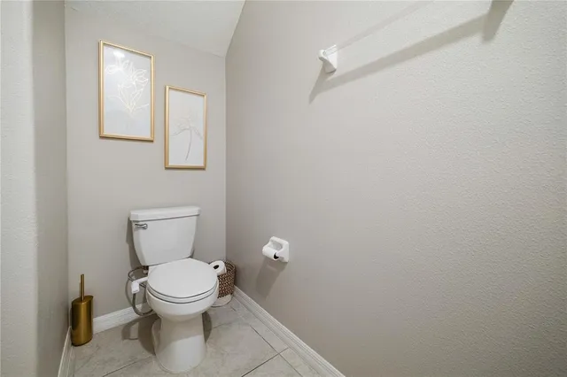 a white toilet sitting next to a white wall
