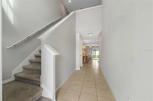 a large kitchen with stainless steel appliances lots of white cabinets a dining table and chairs