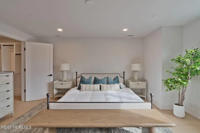 a bedroom with a large bed and a potted plant