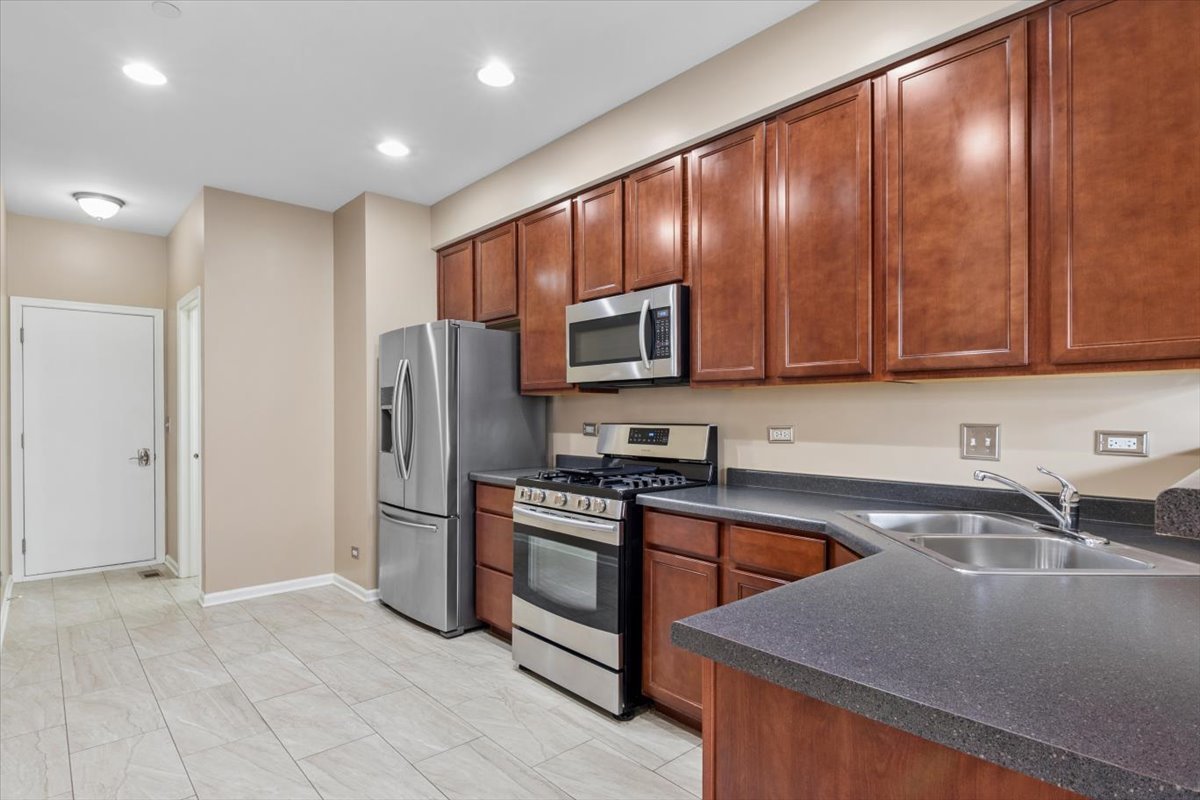 9965 Cummings Street Huntley, IL 60142 - Photo 6 of 23 a kitchen with stainless steel appliances granite countertop a refrigerator stove and sink