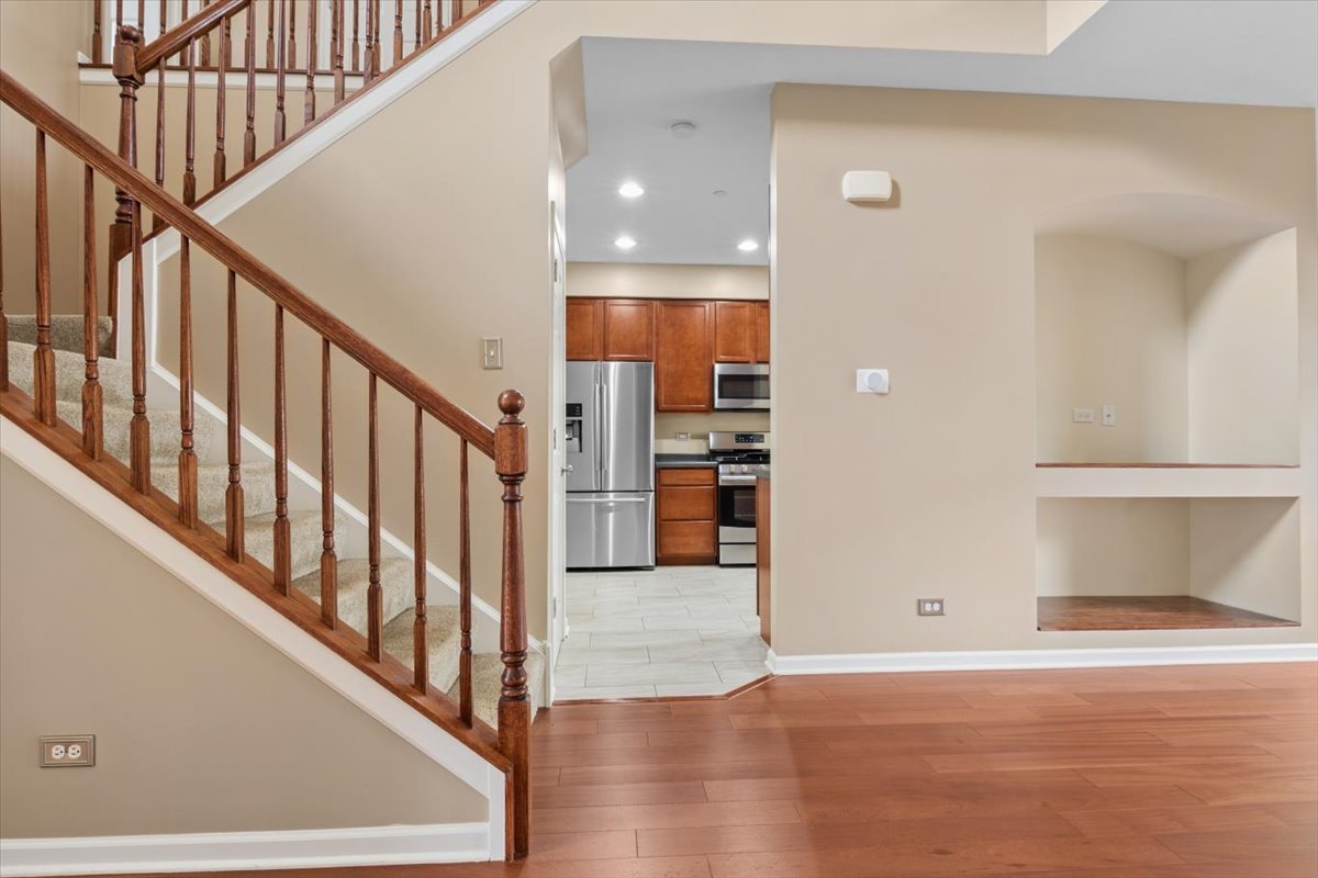 9965 Cummings Street Huntley, IL 60142 - Photo 9 of 23 a view of a hallway with wooden floor and staircase