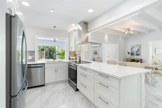 a large white kitchen with a stove a sink dishwasher and a refrigerator
