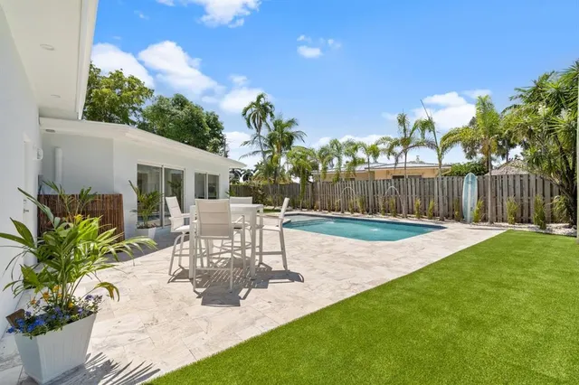 a view of a patio with table and chairs with wooden fence