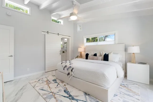 a bedroom with a large bed and a chandelier