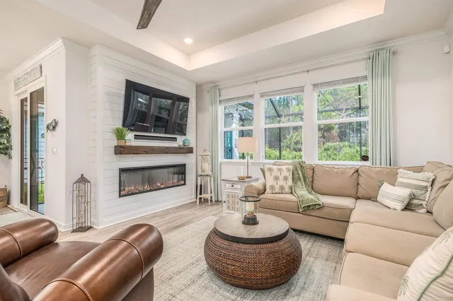 a living room with furniture a fireplace and a large window