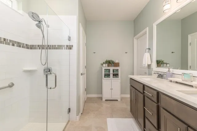 a spacious bathroom with a shower sink and mirror